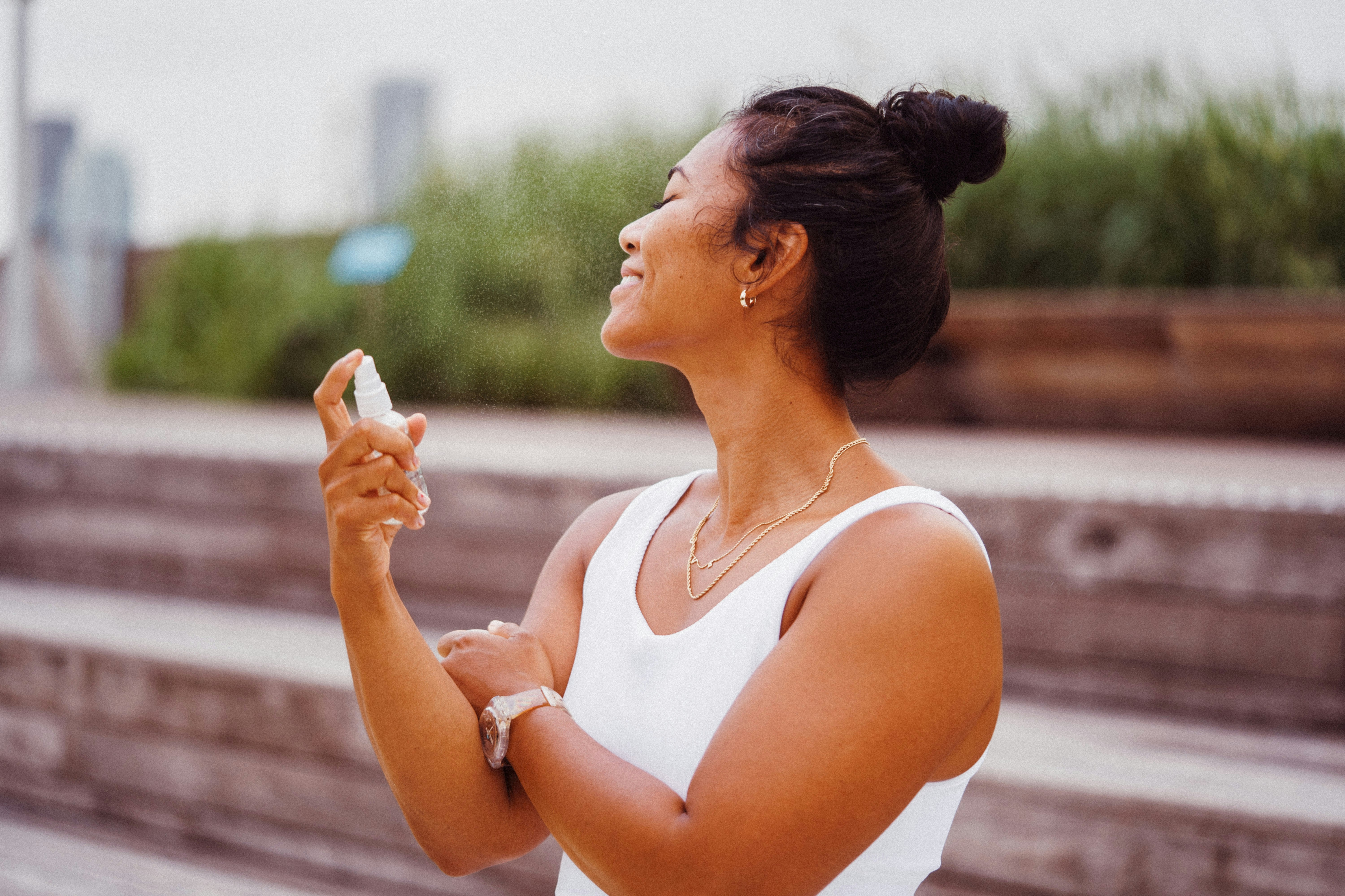 woman in white tank top holding white ceramic mug